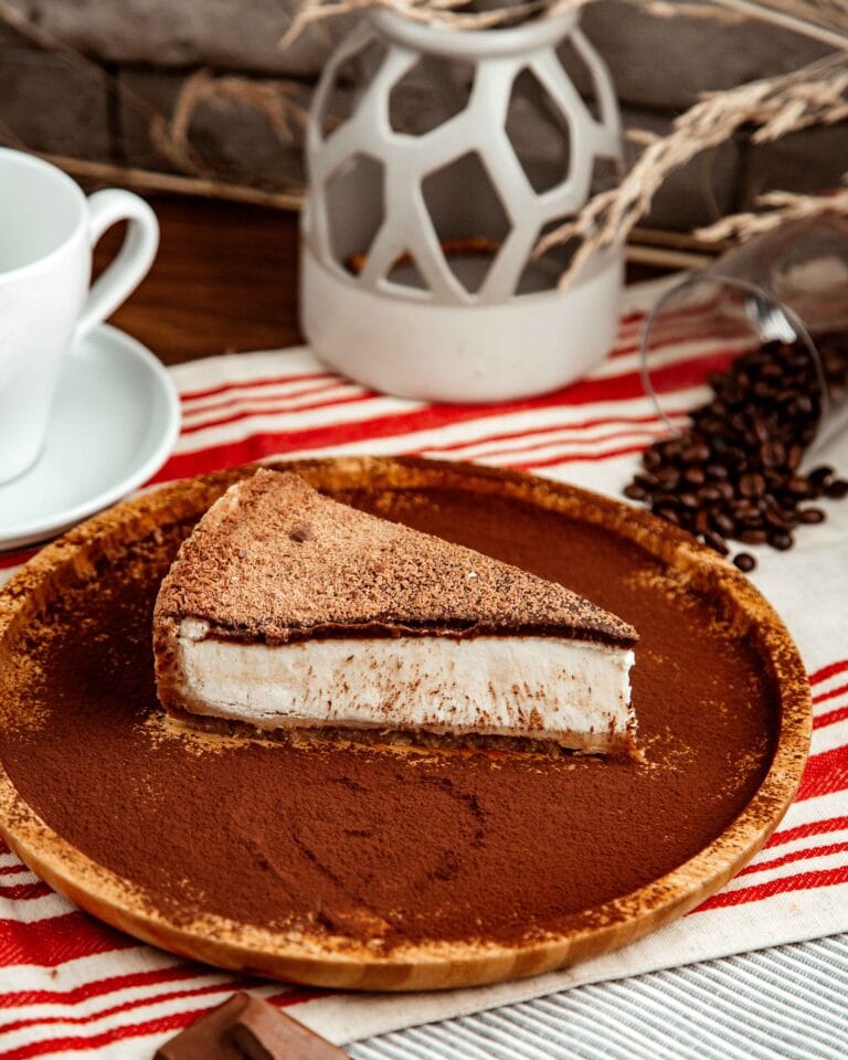 slice of churro cheesecake on a plate with cinnamon-sugar crust and creamy filling