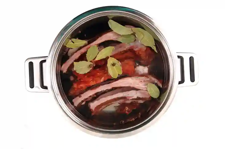 Back ribs in a slow cooker with onions and sauce.