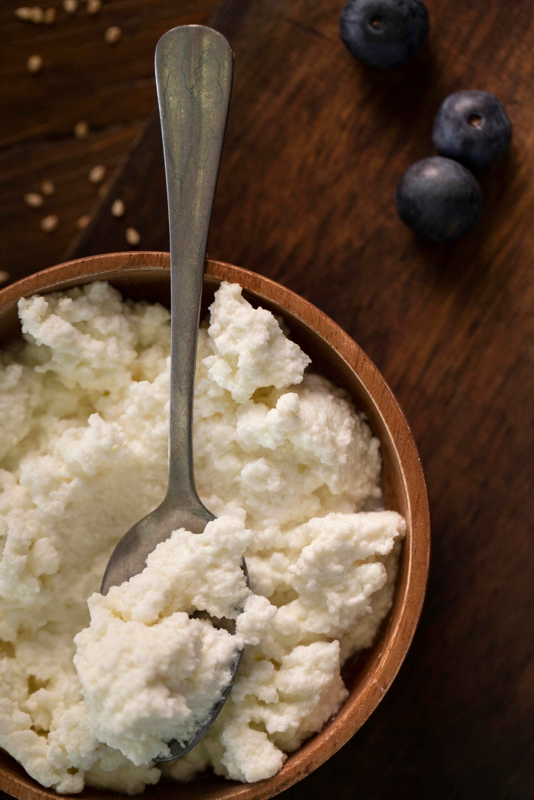 A bowl of creamy cottage cheese served simply on a wooden table.