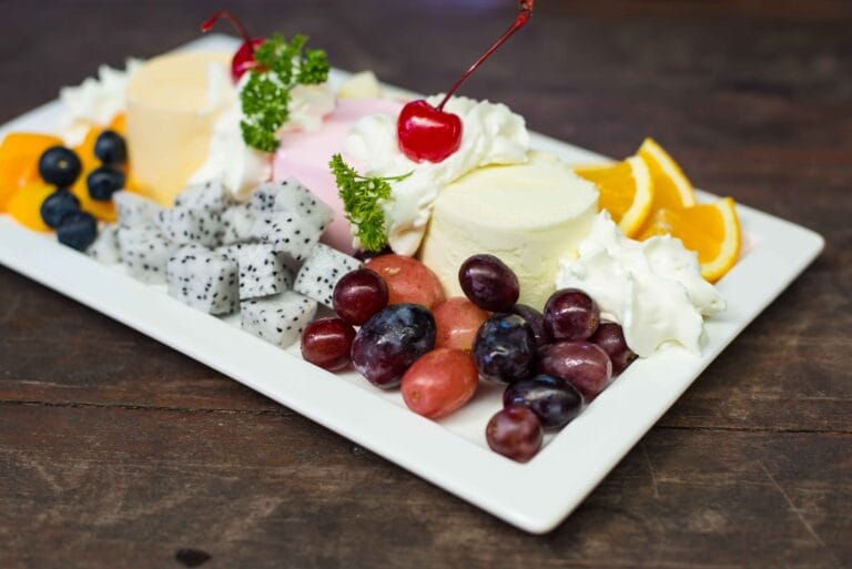 A plate of cottage cheese with fruits and vegetables.