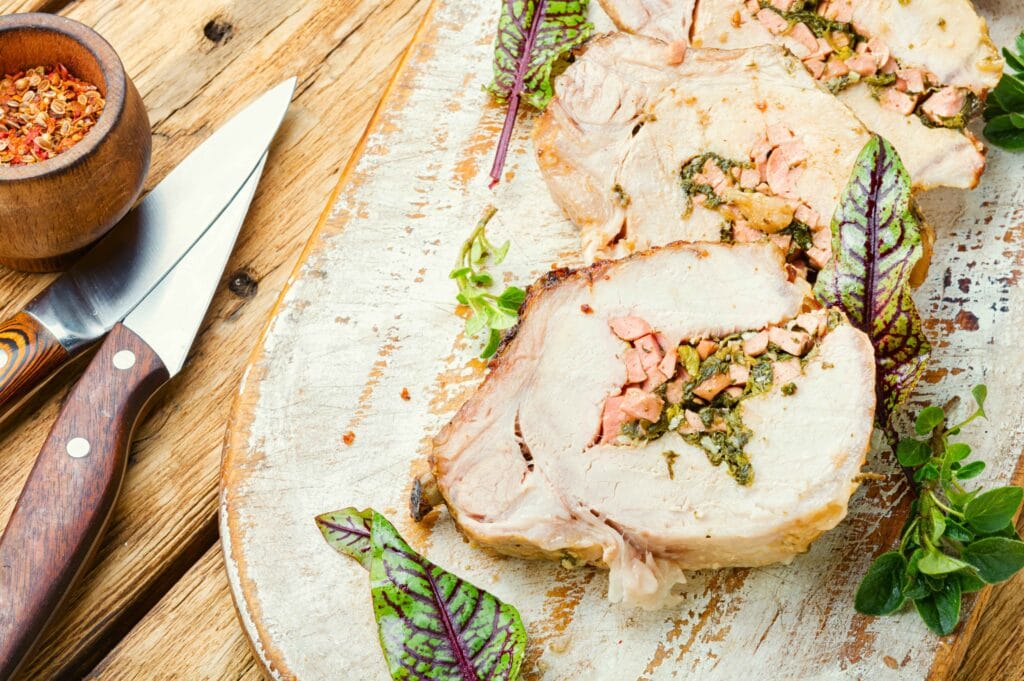 Smoked turkey breast coated with a herb and garlic glaze, sliced for serving on a wooden board