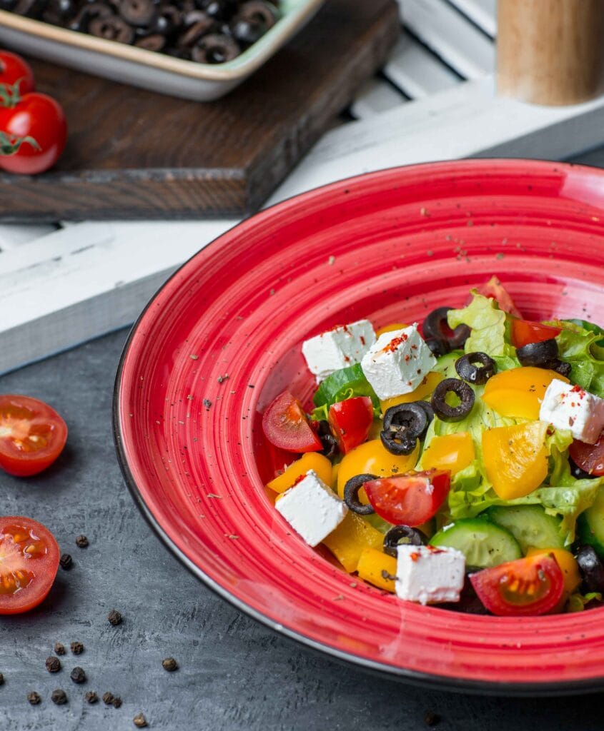 A plate of salad with cottage cheese, cucumbers, and cherry tomatoes.