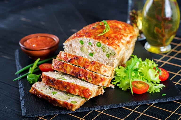 Perfectly baked meatloaf on a wooden board with glaze on top.