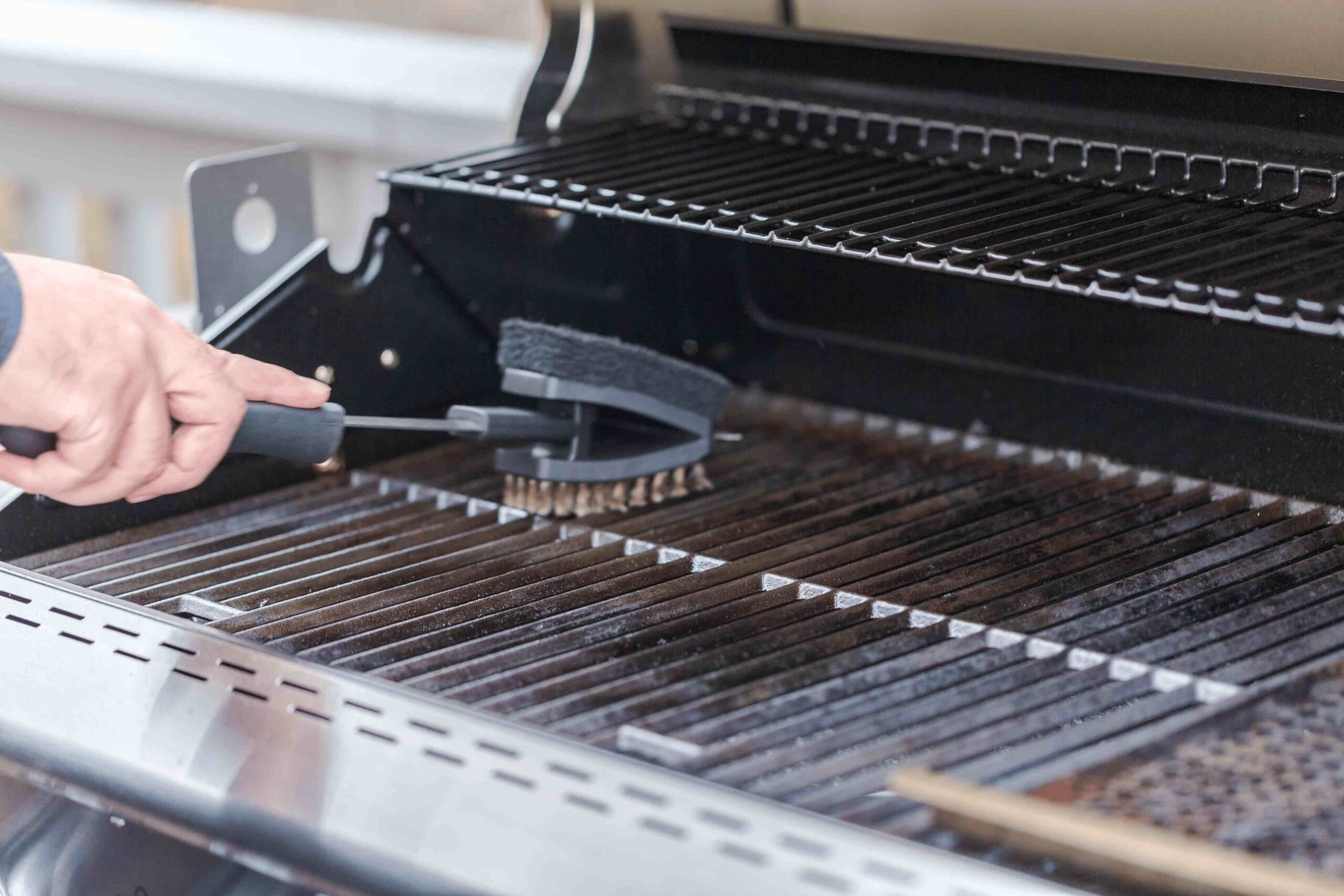 A clean grill ready for cooking with cleaning tools nearby.