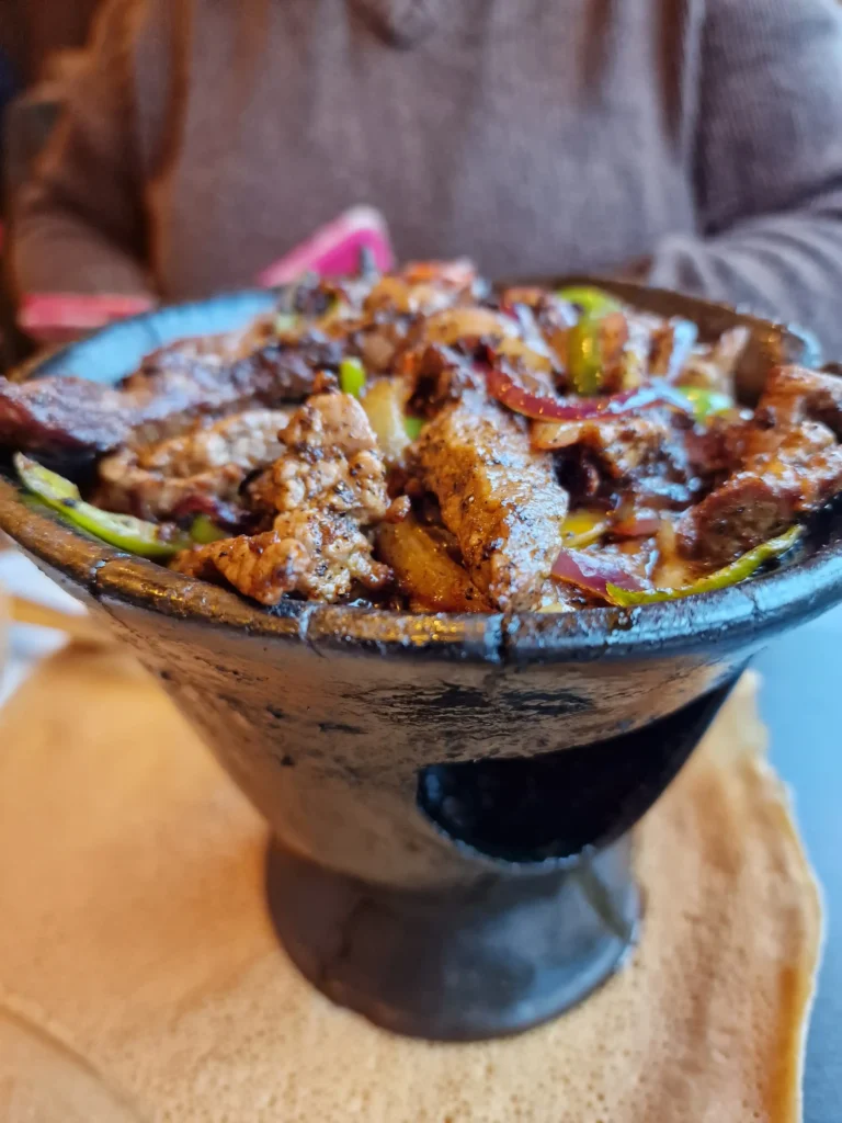 Molcajete mixto served with grilled meats, vegetables, and cheese.