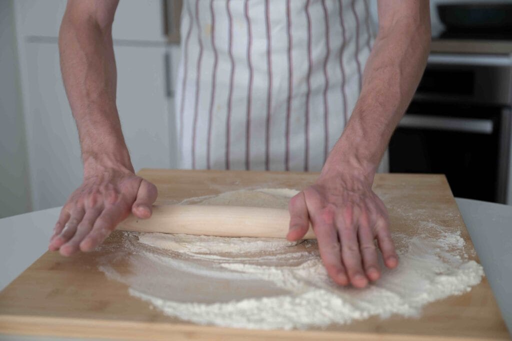 Pie crust being rolled out on a floured surface