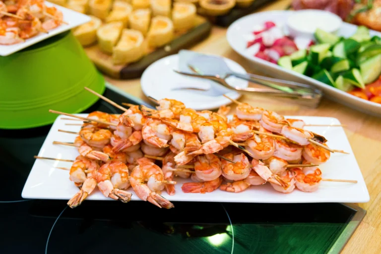 Barbecue shrimp with side dishes like bread, rice, and vegetables.